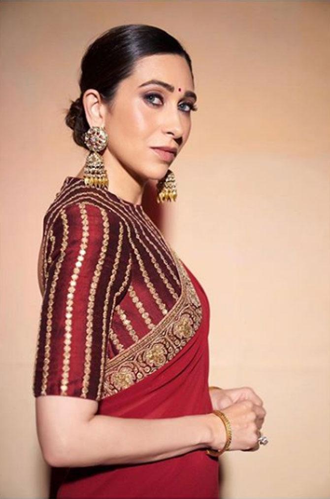 Karisma Kapoor's heavy jhumkis which she paired with a plain red saree defines royalty.