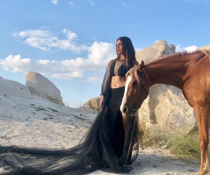 During the launch of her YouTube channel, Mimi stunned her fans by sharing a beautiful photo of herself in an all-black thigh-high slit dress. In the photo, Mimi was seen caressing a horse as she posed amid the scenic beauty of a picturesque destination.