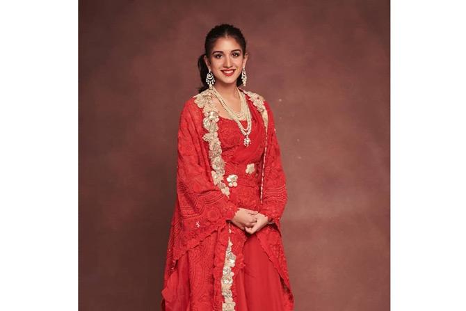 Anant Ambani's friend Radhika Merchant, who has been snapped with the Ambani family on numerous occasions added a splash of colour to the grand pre-wedding bash of Mukesh Ambani's nephew Arjun Kothari. While the entire Ambani family were seen in hues of pastel colours, Radhika stole the show in an all-red ensemble with minimal make-up and accessories. She completed her look by tying her long hair in a neat bun and sported lipstick in shades of red.