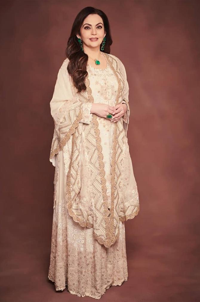 Nita Ambani, who has been setting major fashion goals with her casual attires, traditional looks opted for a bespoke ensemble by designer Anamika Khanna. Nita donned a stunning floor-sweeping, heavily-embroidered off-white Anarkali which she paired with the green emerald neckpiece, emerald green drop earrings, and rings. She complimented her off-white Anarkali suit by draping an off-white dupatta with handiwork details in similar colours.