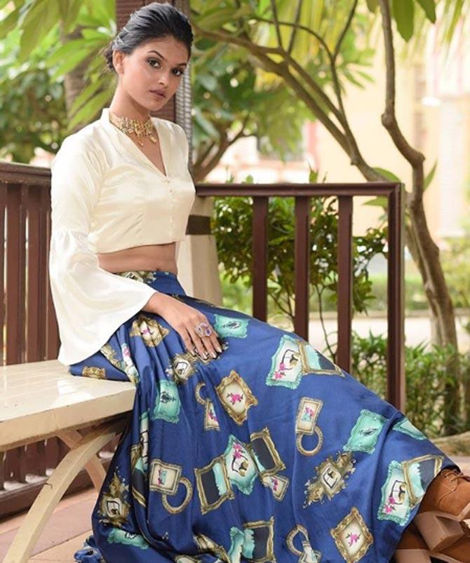 In this blue skirt with quirky prints, Suman dons a full-sleeved white crop top and ties her hair in a bun. The mininal make up and statement jewellery is not something you should miss. 