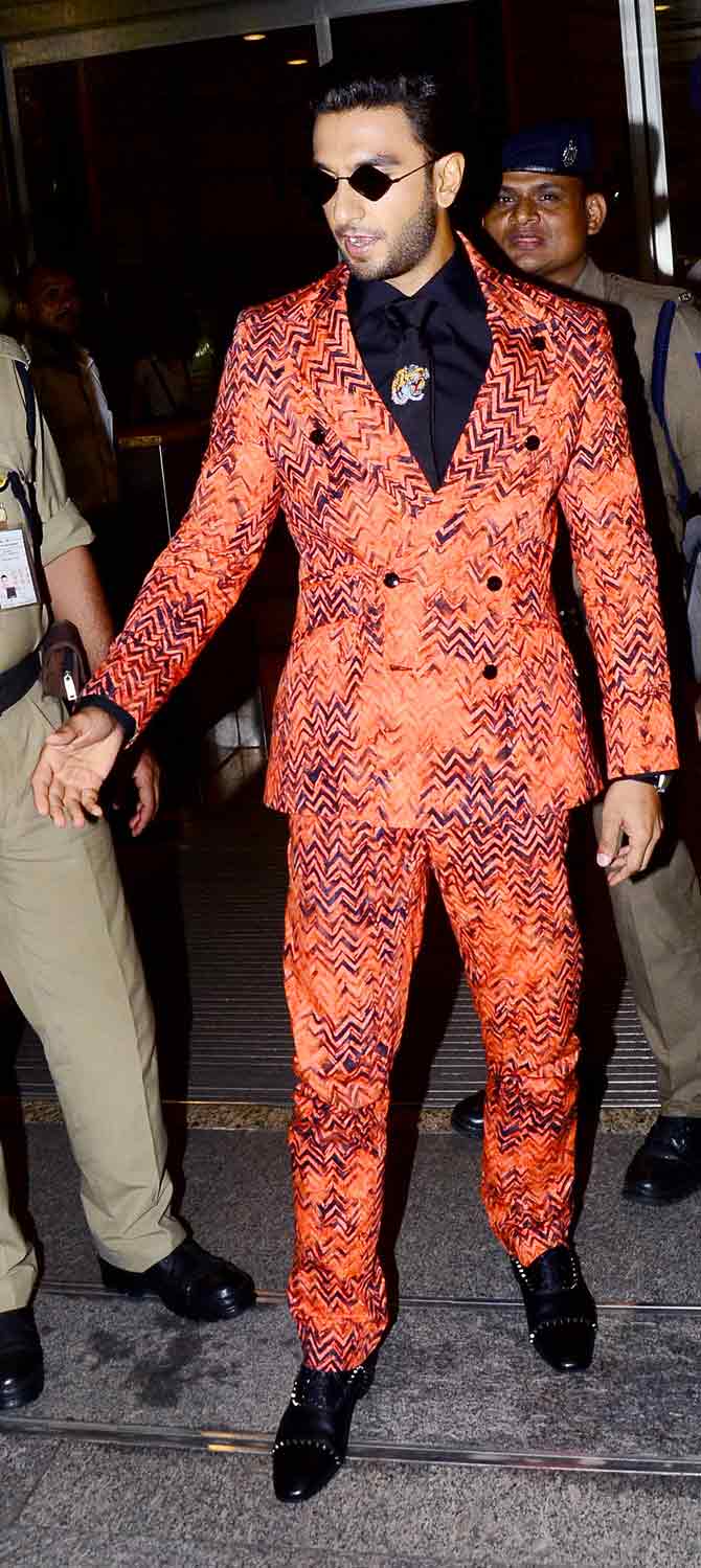 Ranveer opted for a coral suit worn with a black shirt and a black tie for his outing. The actor teamed up his outfit with quirky sunglasses.