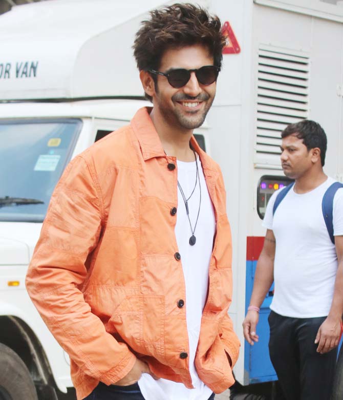 Kartik Aaryan kept it casual in an orange jacket, white tee and denim for the trailer launch of Pati Patni Aur Woh. The trailer shows how Chintu (Kartik Aaryan) is happy and content with his patni, but then the 'Woh' of his life enters and the fun game begins.
