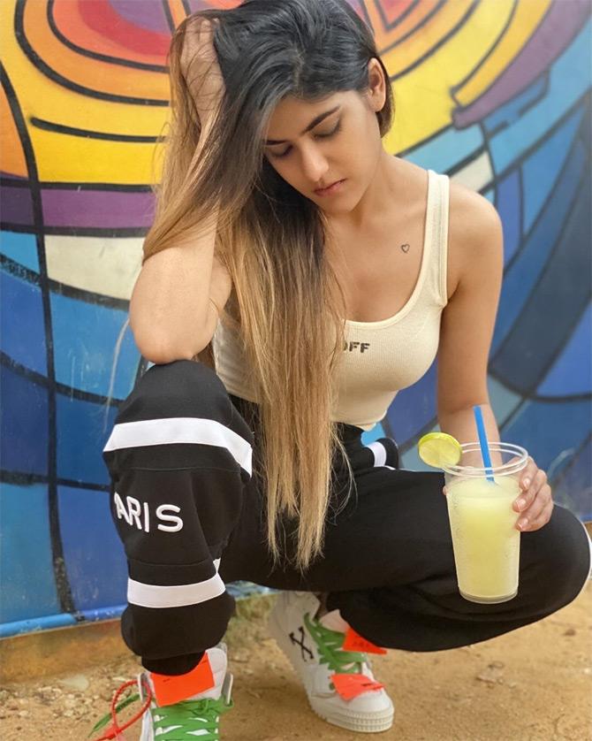 In photo: Ananya Birla caught in a candid moment as she plays with her hair while enjoying a lemon cooler in Singapore.