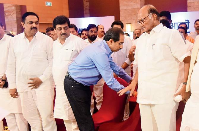 Shiv Sena chief Uddhav Thackeray, who is notably not in neta attire, helps NCP chief Sharad Pawar to his feet during the show of strength at Grand Hyatt on Monday evening. Pic/Rane Ashish