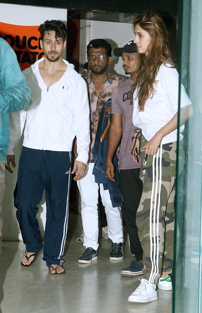 Tiger Shroff and Disha Patani were snapped at a popular dance studio in Andheri, Mumbai. The duo was clicked twinning in a white t-shirt for the outing. While Disha completed her casual look with camouflaged track pants, Tiger opted for a dark blue coloured track pant. All pictures/Yogen Shah