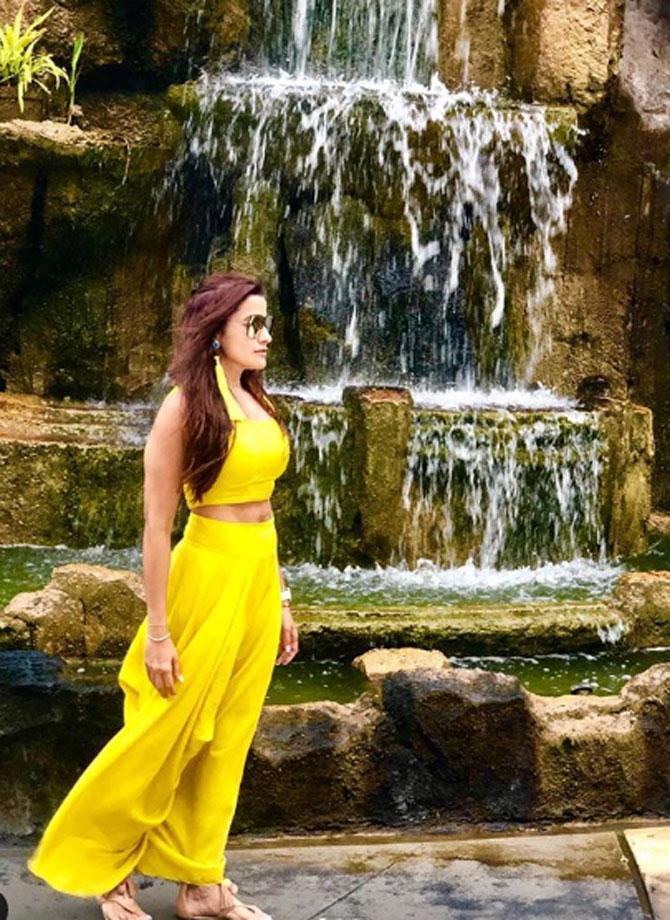 She looks ethereal as she poses in an all-yellow ensemble with a waterfall at the back.
