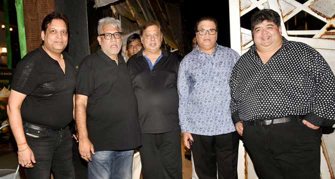 Director David Dhawan, producer Ramesh Taurani, Naresh Malhotra and other guest strike a smiling pose for photographers.