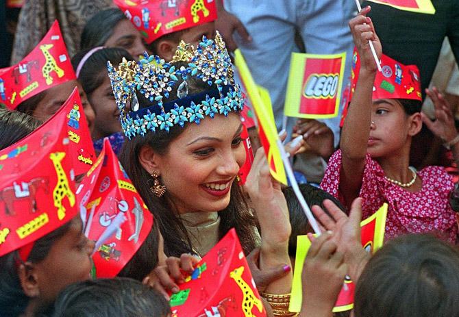 Newly crowned Miss World, Yukta Mookhey, is greeted by children at the Mankhurd Children's Home December 15, 1999, in Mumbai following her return from London. A euphoric India celebrated the victory of the 20-year-old Mookhey who became the fourth Indian to win the Miss World title.