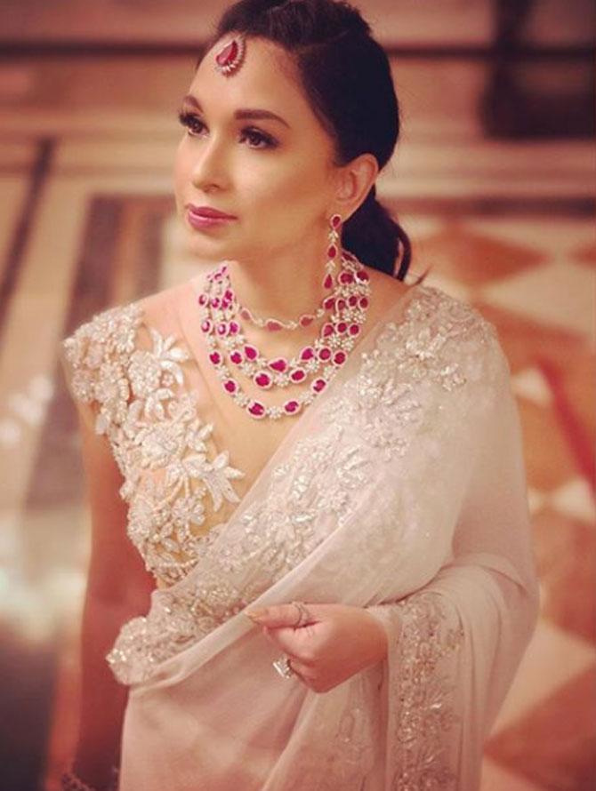 Sheetal Mafatlal personifies elegance and beauty. With a silver ring in her hand and pink studded necklace and earring, she looks ethereal in the white cutwork saree.