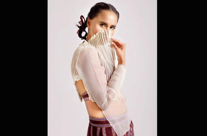 Asymmetrical sheer top with cording and bead details layered over khun bralette and paired with striped khunn pants