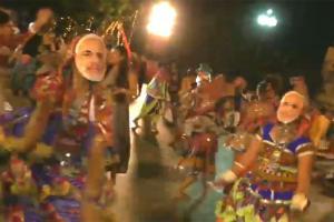 People wear Modi masks while performing 'Garba' in Surat