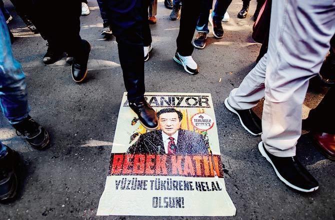 Protesters step on a poster with an image resembling Chinese President Xi Jinping in Istanbul