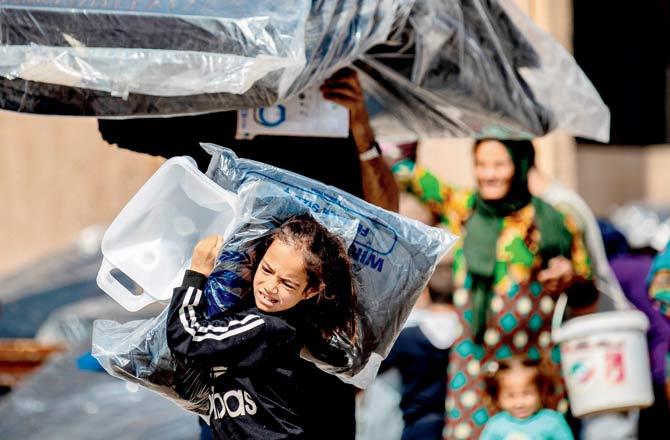 Displaced Syrians, who fled their homes in Ras al-Ain, receive aid on Sunday. Pics/AFP