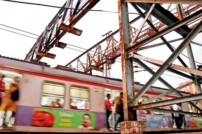 Rusted portions of the bridge hang precariously over the railway tracks at Dombivli station