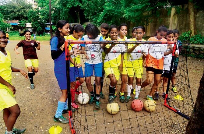 Football players from Educo Sai Baba Path Municipal School huddle around a goal post they got after a three-year wait. Pic/Atul Kamble