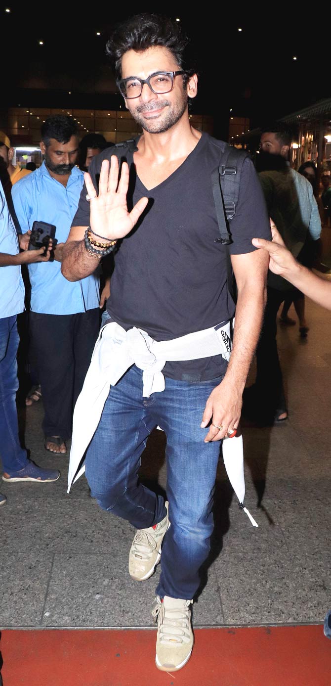 Bharat actor Sunil Grover waves at the photographers as he arrived at the Mumbai airport.