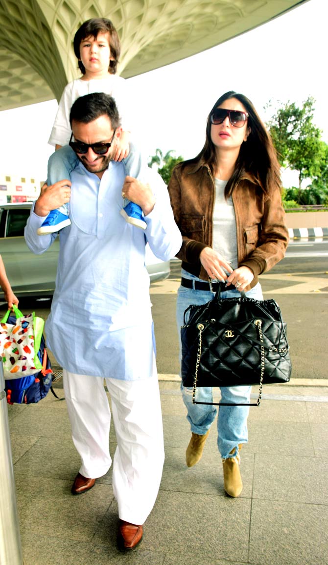 Saif Ali Khan with wife Kareena Kapoor Khan and son Taimur Ali Khan were spotted at the Mumbai airport. Saif looked dashing in his blue kurta, white pyjama with brown boots, while Bebo wore a brown jacket, white tee and jeans. Little Tim wore a white top and denim with blue baby shoes. All pictures/Yogen Shah