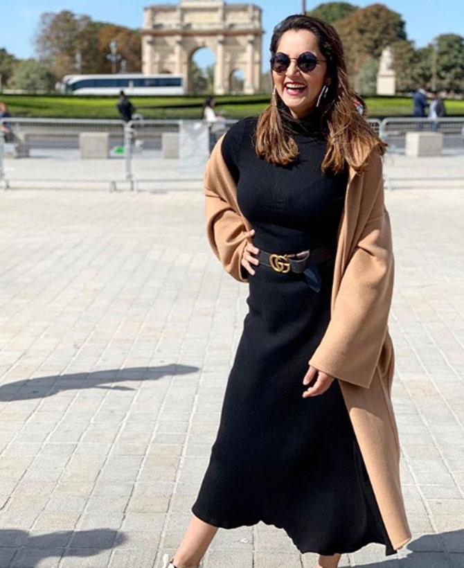 Sania Mirza wore a beautiful black dress and a cream coat with sunglasses and white sneakers for her Paris trip. Sania captioned the photo, 'Cause happy girls are the prettiest'