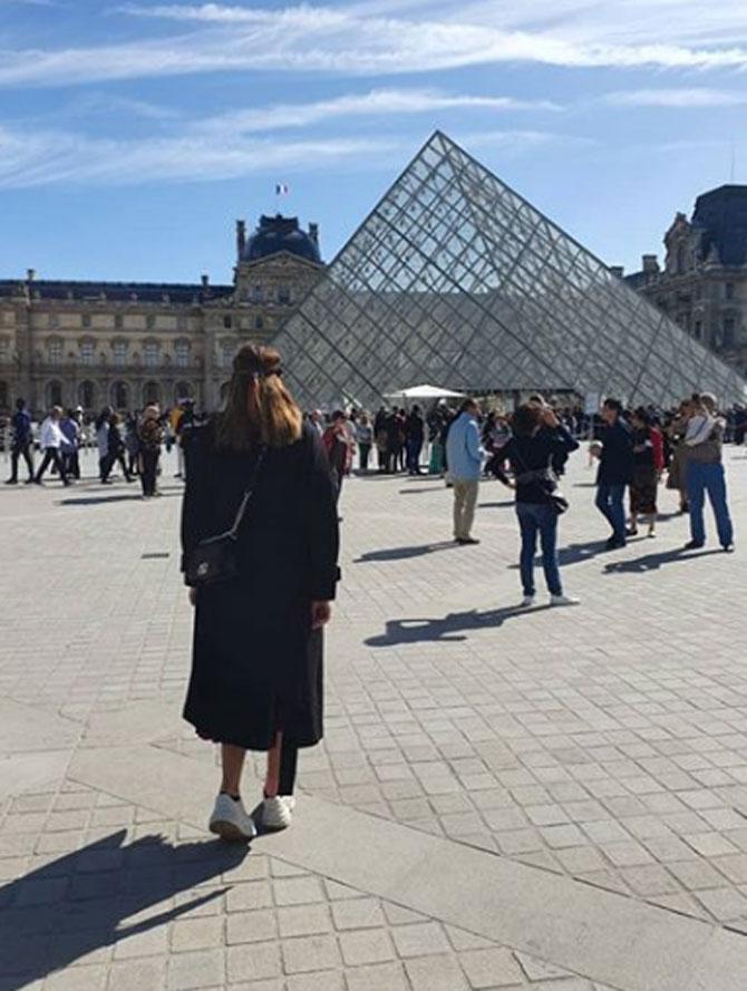 Anam Mirza shows off her long black coat as she walk the streets of Paris