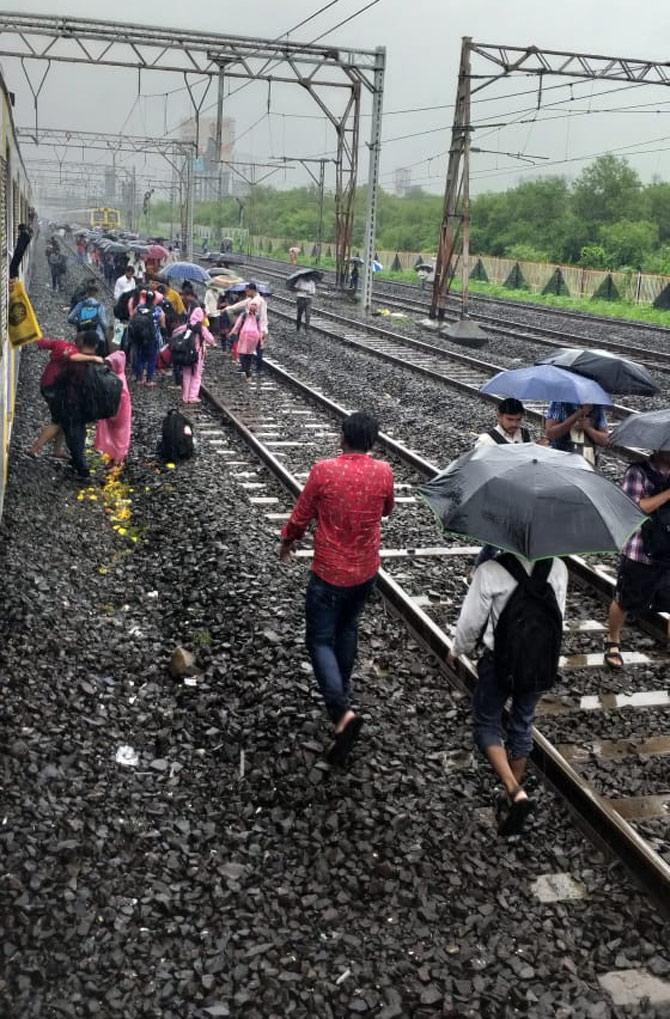 In picture: Waterlogging disrupts train services between Mahim-Matunga and people are seen walking towards a nearby station
(Picture courtesy/Rajendra B Aklekar)