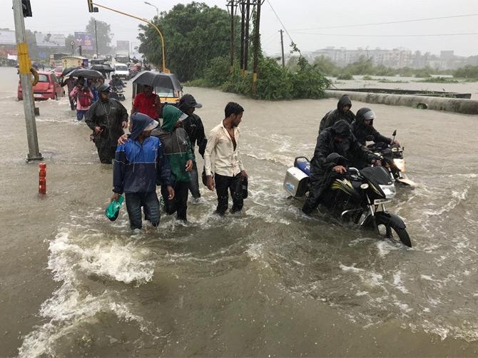 In the picture, people walk as riders ride through the waterlogged streets in Nalasopara
(Picture courtesy/Samiullah Khan)