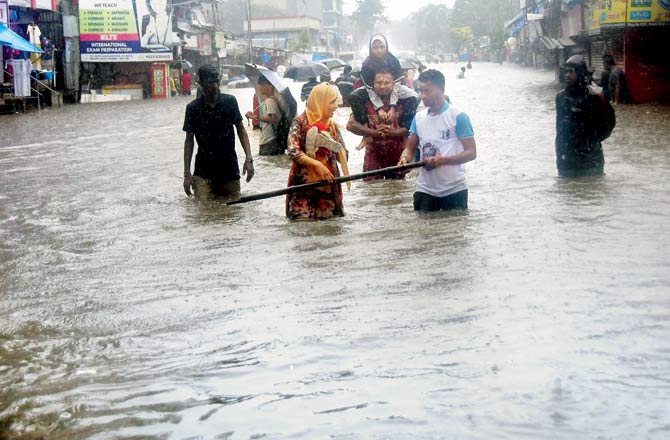 People trying to find their way through a heavily waterlogged road in Andheri. Pic/Sayyed Sameer Abedi