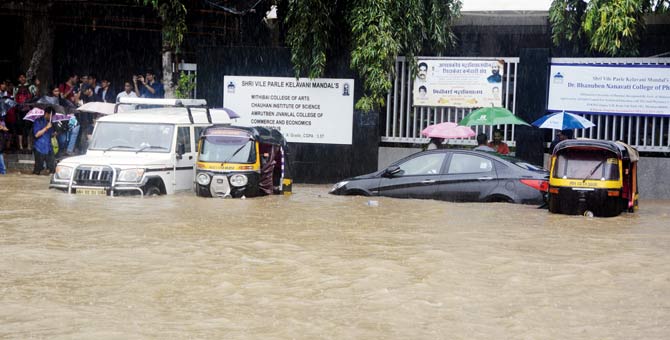 Cars drown in the waterlogged road at outside Vile Parle station at SV Road. Pic/Sneha Kharabe