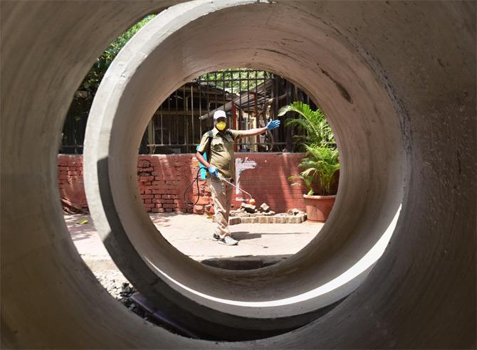 In photo: A BMC employee disinfects the place outside G South ward office, near Deepak talkies at NM Joshi Marg, Elphinstone. 