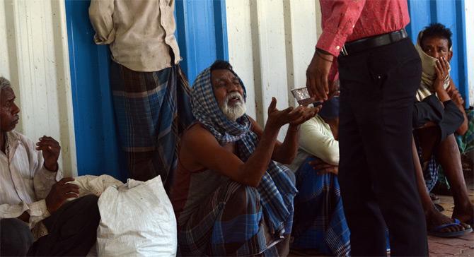 In photo: A volunteer offers a food packet to a needy person amid total lockdown.