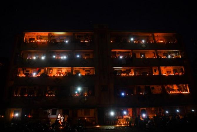 Residents stand at their balconies and light candles and flash mobile torches in support of PM Modi's initiative. (Photo: AFP)