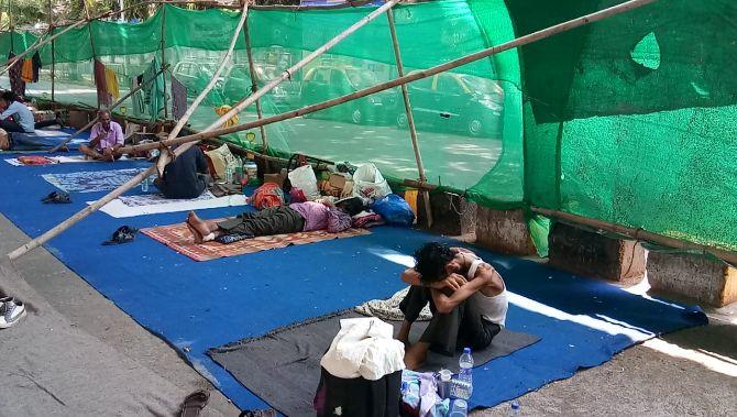 The relatives of the patients who have been admitted in Tata Cancer hospital rest under a tent in the city amid lockdown.