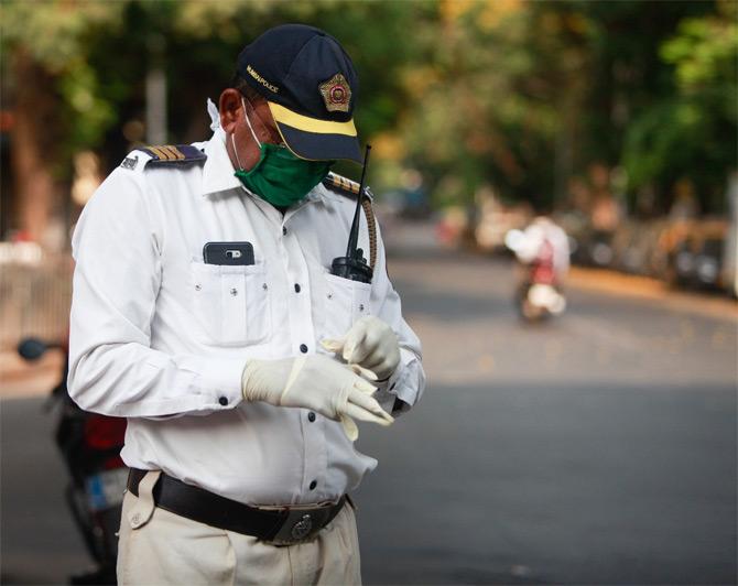 In photo: A Mumbai Police Traffic personnel snapped while wearing hand gloves to fight the spread of coronavirus.