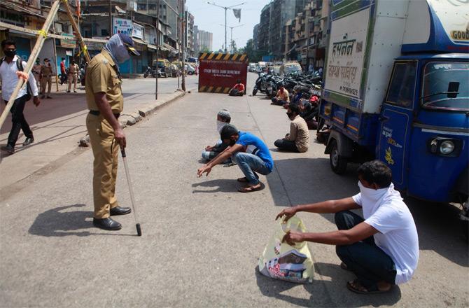 In photo: Mumbai police personnel punish people for breaking lockdown rules and roaming freely on the streets.