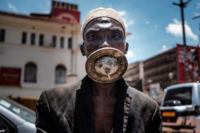A man wearing an alternative mask poses for a photograph in the Ugandan city of Kampala.