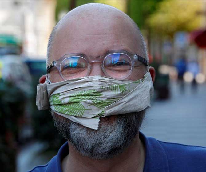 A man poses with a handmade protective face mask, made out of a paper napkin, in Sceaux, south of Paris in France.