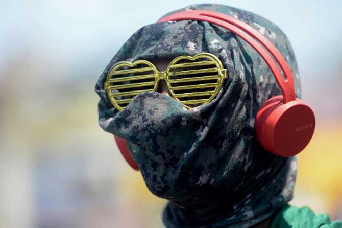 A man wearing heart-shaped glasses with his face covered amid fears of the spread of the COVID-19 novel coronavirus, stands at market during a government-imposed nationwide lockdown as a preventive measure against the COVID-19 coronavirus, in Chennai, state capital of the state of Tamil Nadu.