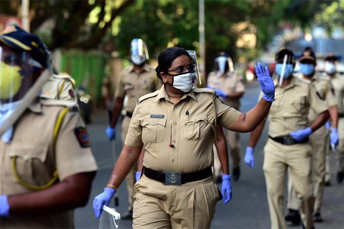 In photo: A woman police personnel waves at the crowd during the flag march at Walkeshwar in South Mumbai.