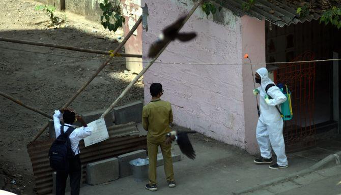 A municipal worker sprays disinfectant in an alley in Pratiksha Nagar in Sion, where a patient had tested positive for the virus during a government-imposed nationwide lockdown as a preventive measure against the COVID-19 coronavirus 