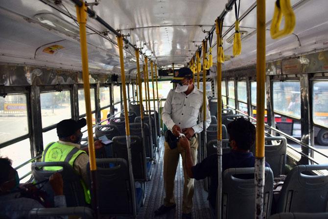 In photo: A traffic police constable checks the Id cards of essential workers travelling in BEST buses amid lockdown in the city.