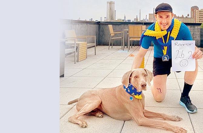 England poses with his dog Miles, as he proudly displays the finisher