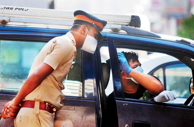 A police officer checks a vehicle in South Mumbai