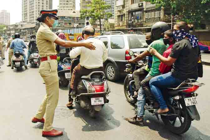A police officer speaks to people caught riding during the lockdown. PIC/Suresh Karkera