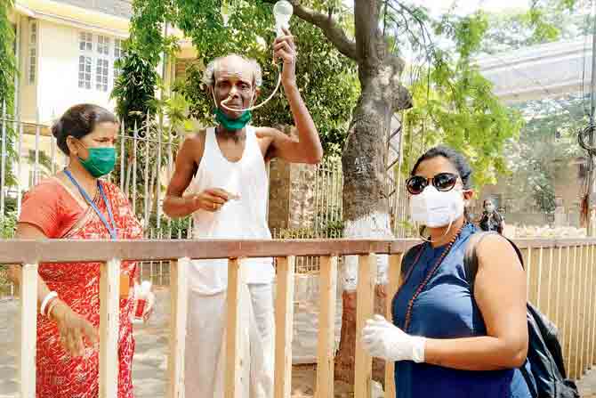 Kranti NGO’s Bani with a couple from Kolkata on April 2. The man was discharged from the cancer hospital the day before the lockdown was announced. Since he cannot stomach solids, she hands him a one litre milk packet daily