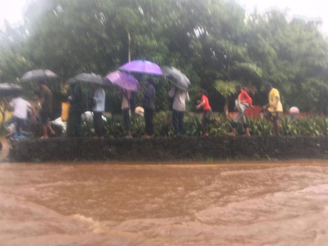 In photo: People walking on the road divider in Wadala to avoid flooded streets.