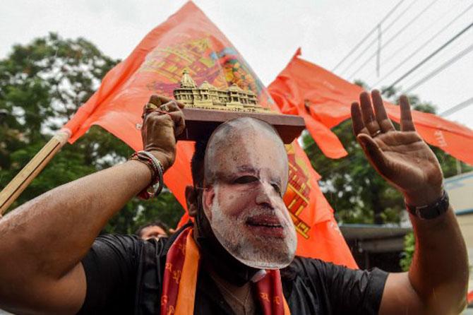 A BJP supporter snapped wearing a mask with a photo of Prime Minister Narendra Modi on it, during celebrations.