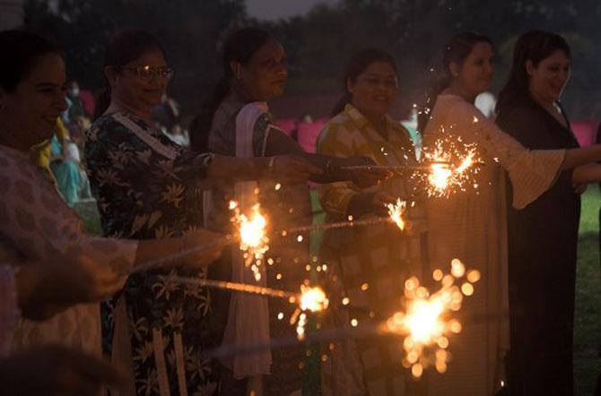 In photo: People light sparklers as they celebrate on the outskirts of Amritsar.