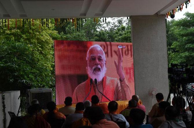 BJP supporters watch a live telecast on a giant screen at Gujarat BJP headquarters in Gandhinagar.