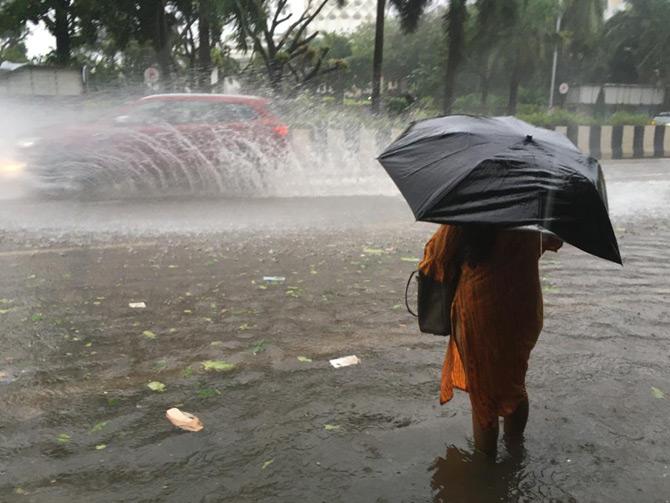 According to Brihanmumbai Municipal Corporation (BMC), the western suburbs received 82.43 mm rain, followed by eastern suburbs (69.11 mm) and the island city (45.38 mm) since Tuesday night.
In picture: A motorist splashes water while driving on a waterlogged road as a woman looks on, in Worli.
