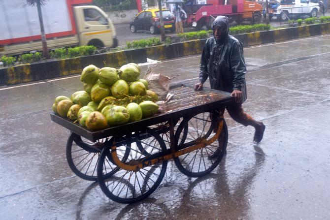 In picture: A tender coconut seller pushes his cart amid the heavy rains in Saath Rasta near Arthur Road Jail.